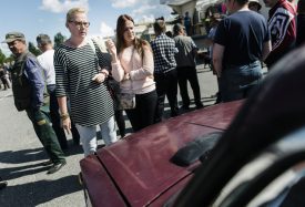 Kristiina Lappalainen and daughter Malla view one of the cars on auction during an auction as Asylum seekers' abandoned cars in Salla, northern Finland, on Friday July 15, 2016. Over 100 old cars, mostly Russian-made, driven across the northeastern Finnish border by asylum seekers and abandoned at the Salla border crossing point this past winter are auctioned in a two-day event in Salla. (Jouni Porsanger/Lehtikuva via AP) FINLAND OUT - NO SALES